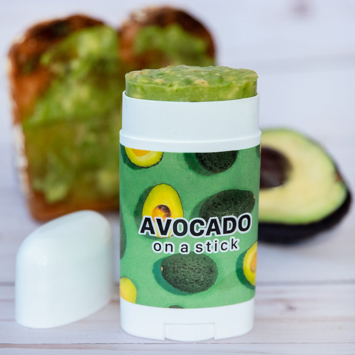 A green tube labeled Avocado on a Stick with avocado protruding from the top.