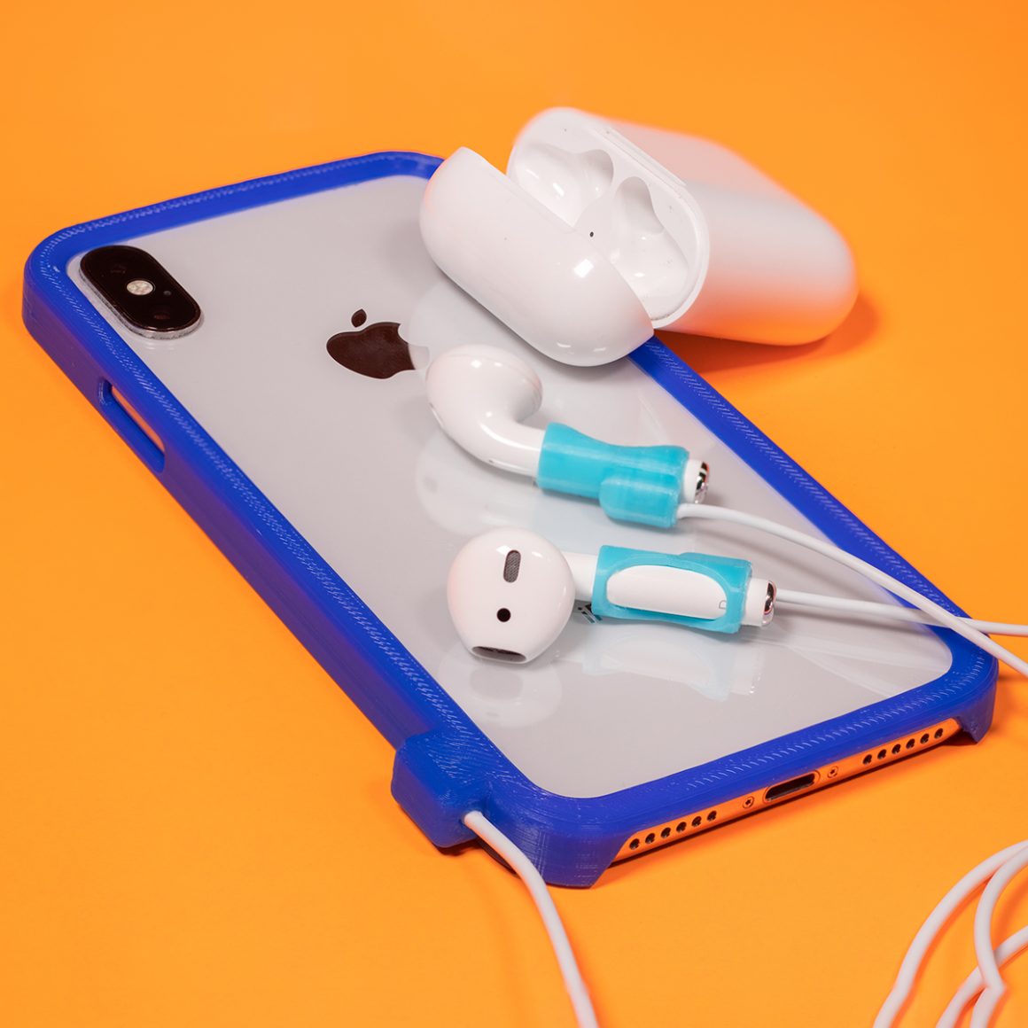 AirPods attached by light-colored cords to a blue-edged iPhone case.