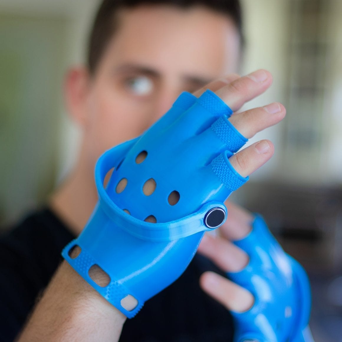 Matty wearing blue perforated foam gloves with straps across the backs of his hands.