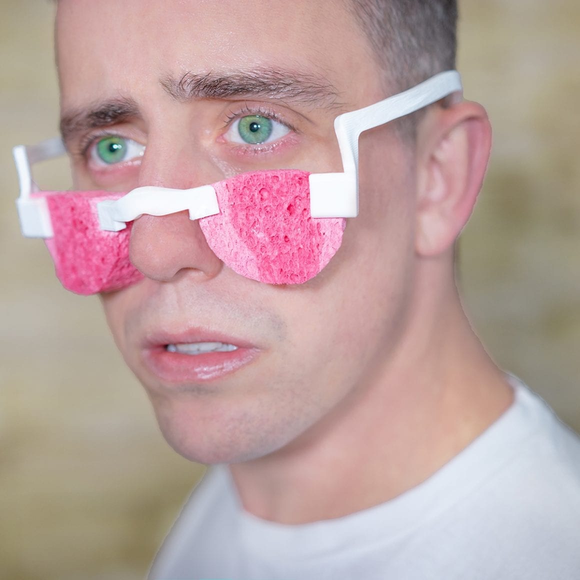 Matty wearing white glasses with pink sponges positioned below his eyes.
