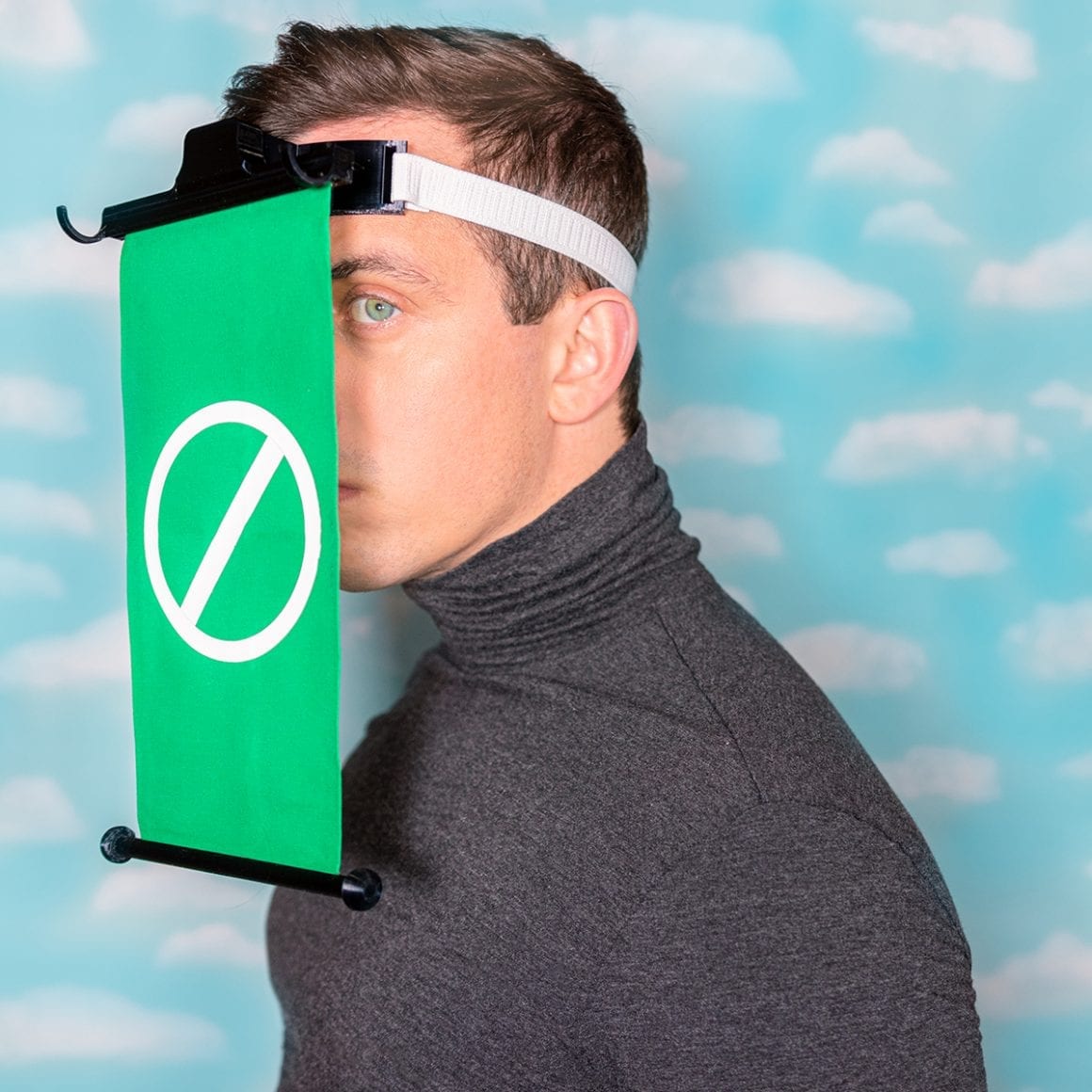 Matty wearing a backward cap with a green no-entry screen hanging in front of his face.