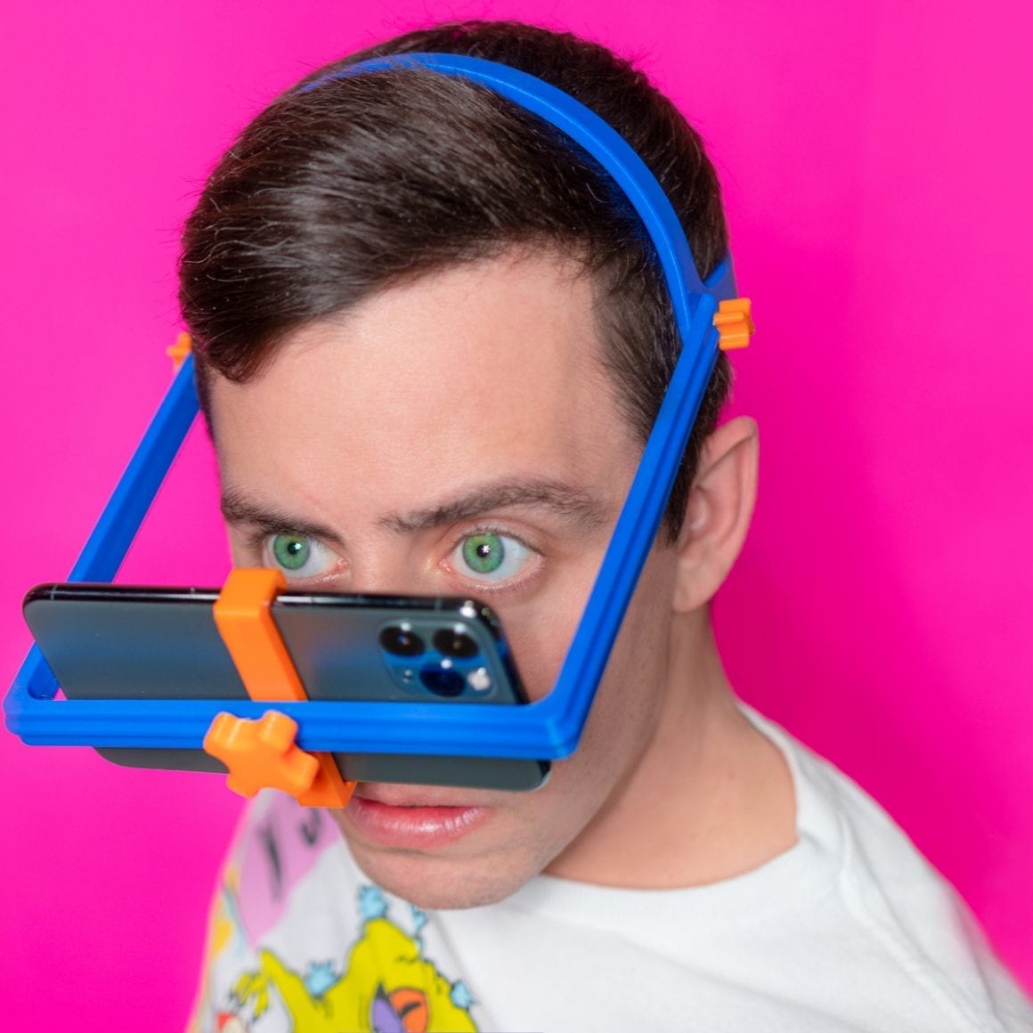 Matty wearing a blue head frame with a smartphone secured horizontally by orange fittings.