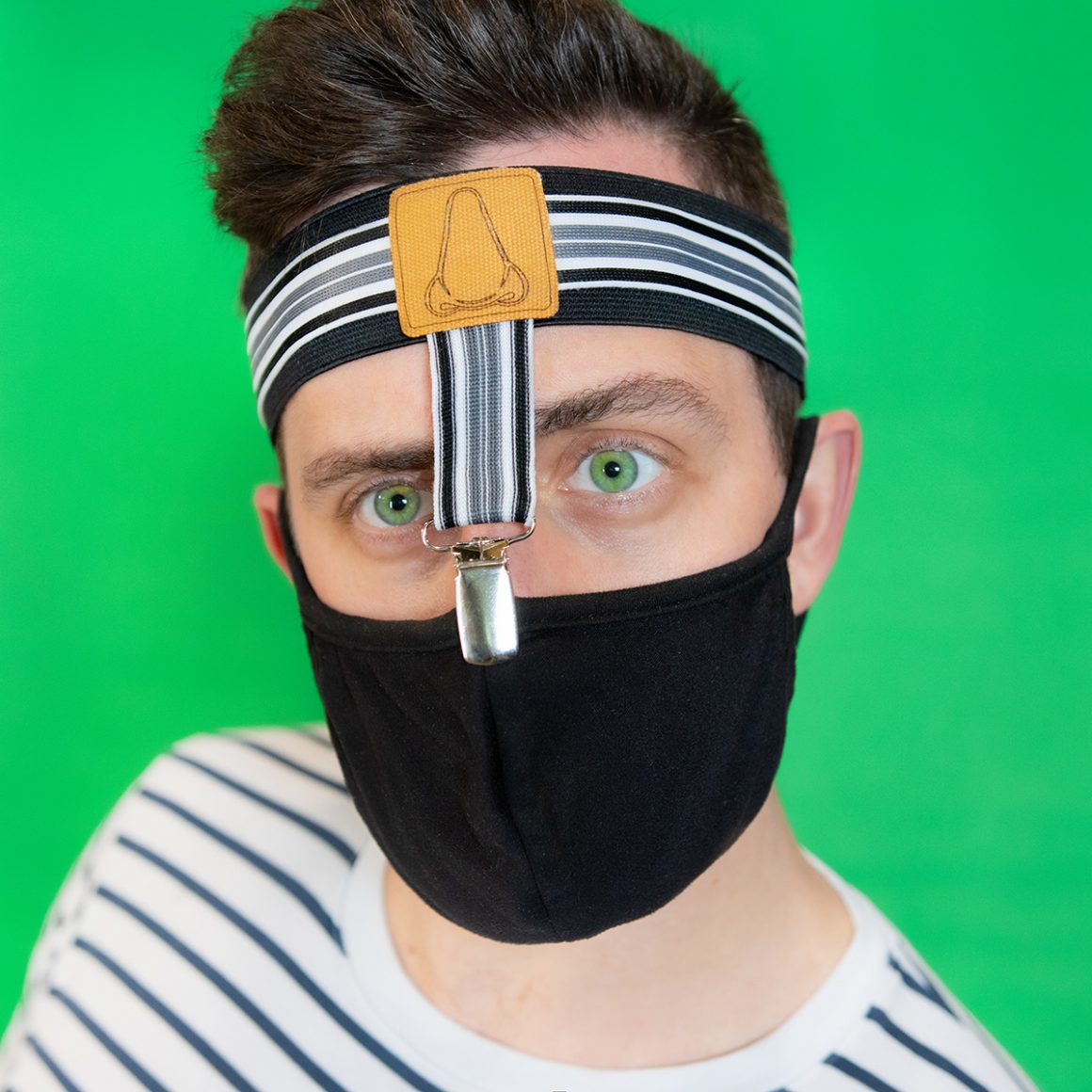 Matty wearing a black face mask held up by miniature suspenders attached to a headband.